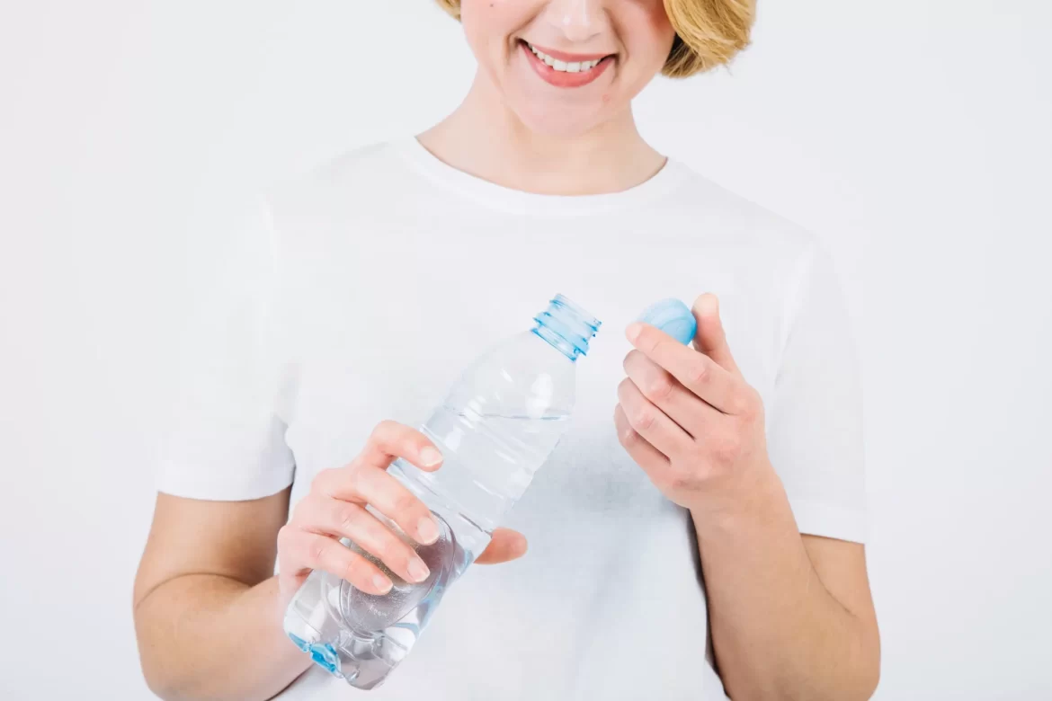 apakah air bisa kadaluarsa - gambar perempuan memegang botol yang terbuka