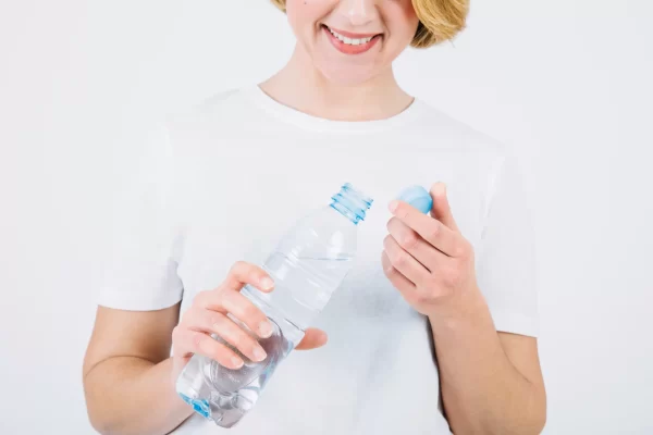 apakah air bisa kadaluarsa - gambar perempuan memegang botol yang terbuka